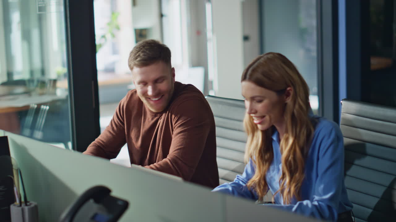 Positive colleagues communicating workplace closeup. Smiling woman typing laptop