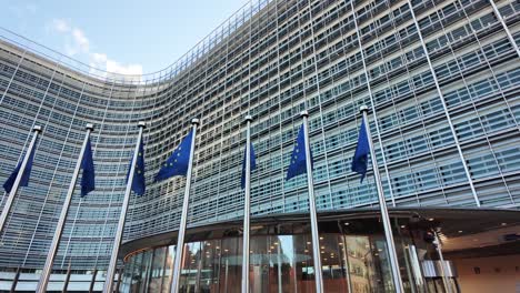 european commission berlaymont building with eu flags waving in brussels