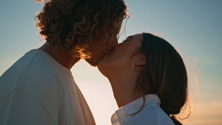 Un couple s'embrasse au coucher du soleil