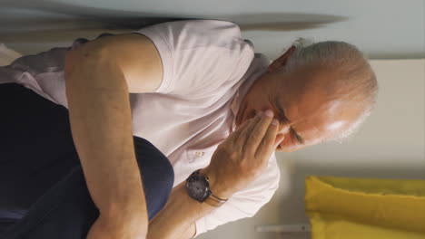vídeo vertical del anciano sentado en el suelo está llorando. abatido.