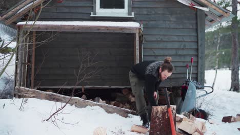 un hombre activo está apilando troncos de madera después de cortar afuera durante el invierno