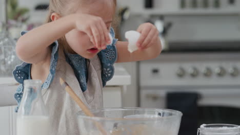 cute little girl breaking egg in bowl mixing ingredients preparing recipe for homemade cupcakes having fun baking delicious treats in kitchen 4k