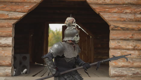 evil knight with spear walks through courtyard for battle