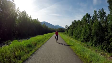 mujer montando un monociclo en la carretera del campo 4k