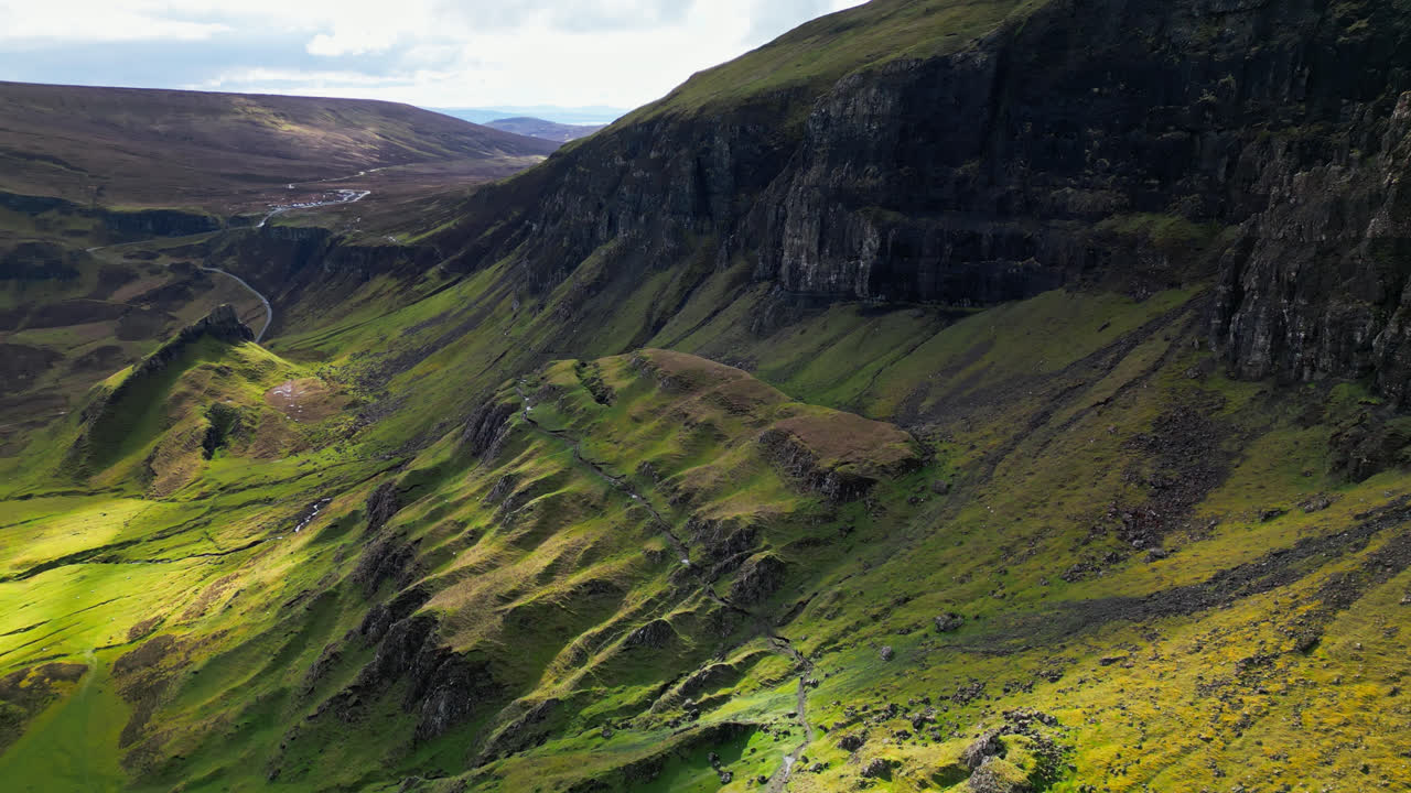 드론은 스코틀랜드 고원에 있는 잔디로  ⁇ 인 노출된 바위의 질감 패턴을 드러내기 위해 아래로 기울입니다.