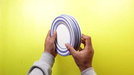 persona que sostiene una pila de platos