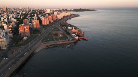 aerial view descending to montevideo gran bretaña coastal highway road alongside playa del gas sunlit high rise cityscape