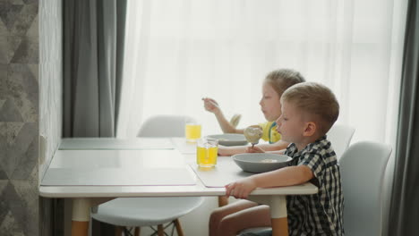 children eating breakfast at the kitchen table