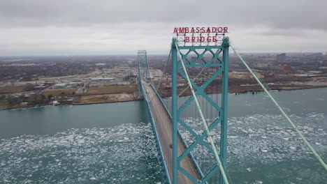 the waterfront of detroit, michigan in winter with the ambassador bridge in the foreground