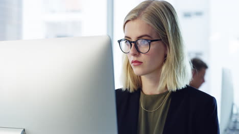 mujer trabajando en una computadora en una oficina moderna