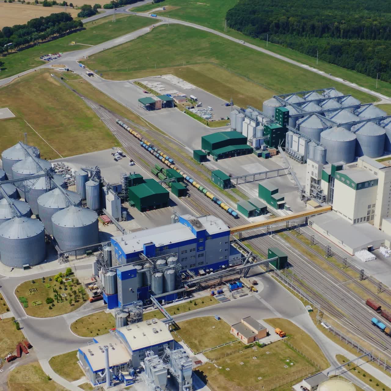Innovative plant on field. Modern elevators for storage agricultural products. New equipment at the plant for the processing, storage of grain crops.View from above.