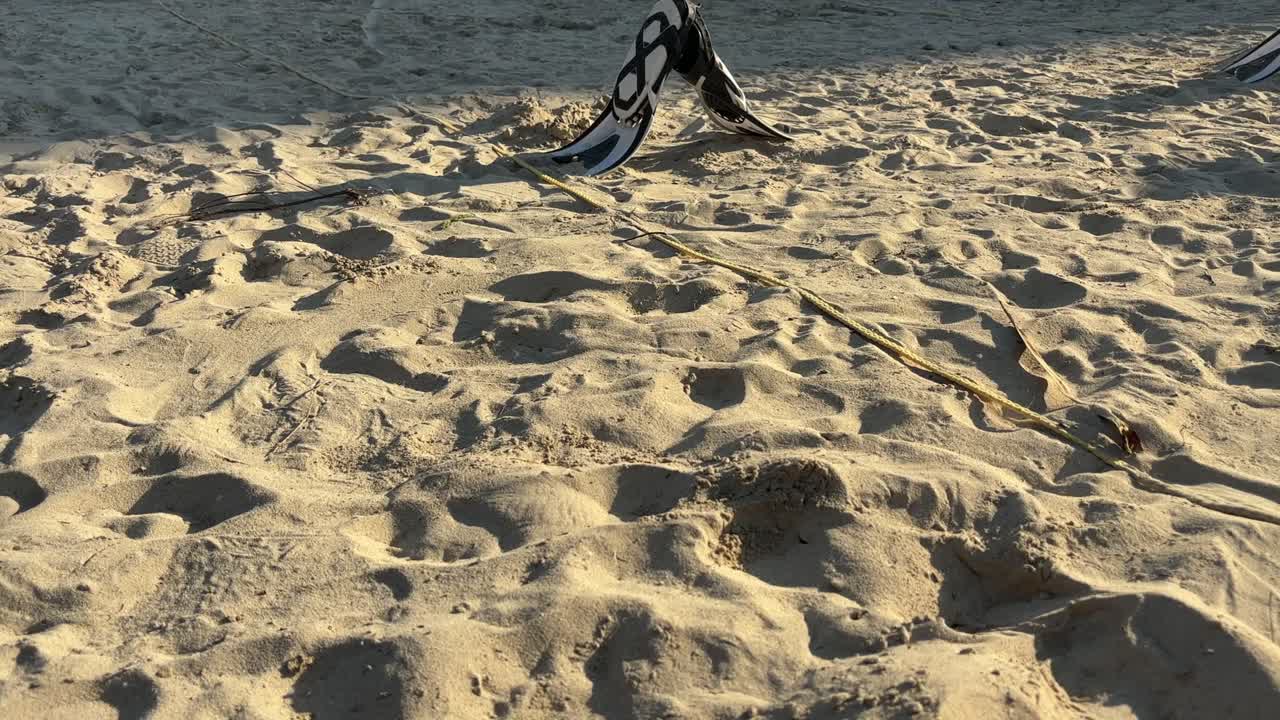 따뜻한 햇살 아래 스페인 마요르카 섬의 칼라 그란 해변 황금빛 모래사장 위에 놓인 안전 요원용 오리발