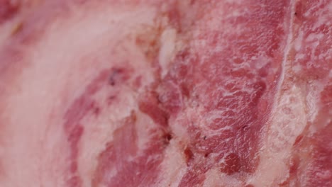 black bull sausage ham, tongue pork dry-cured sausage on a black background, traditional spanish delicatessen food, close up.