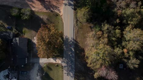 Drone-aerial-rising-away-from-bicycle-riders-on-country-road