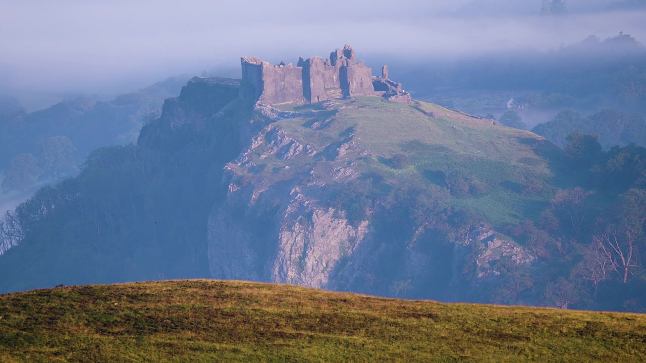 Paneo ascendente que revela un plano de establecimiento del Castillo de Carreg Cennen en la cima de una montaña. Arquitectura de la historia galesa de la Edad Media.