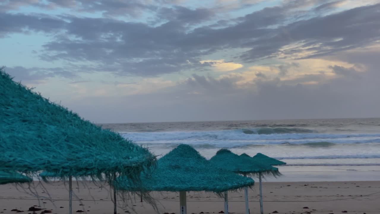 vista de la hermosa escena de la playa con el mar en el horizonte y un paraguas de viento en la arena en vacaciones de invierno y concepto de destino turístico tropical
