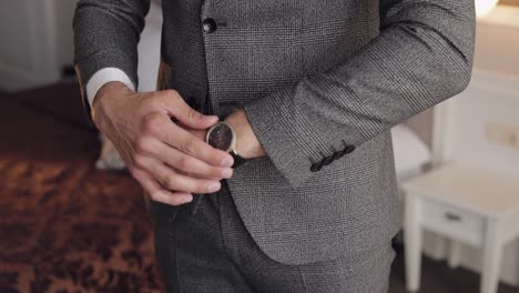 man put on wrist watch, groom dresses, male businessman waiting for meeting, hand with clock