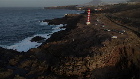 aerial: circling around the famous faro de sardina, lighthouse tower in gran canaria