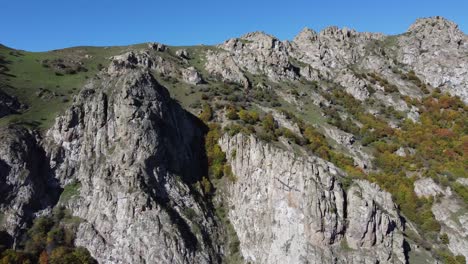 golden fall foliage on rugged mountain slopes under clear blue sky