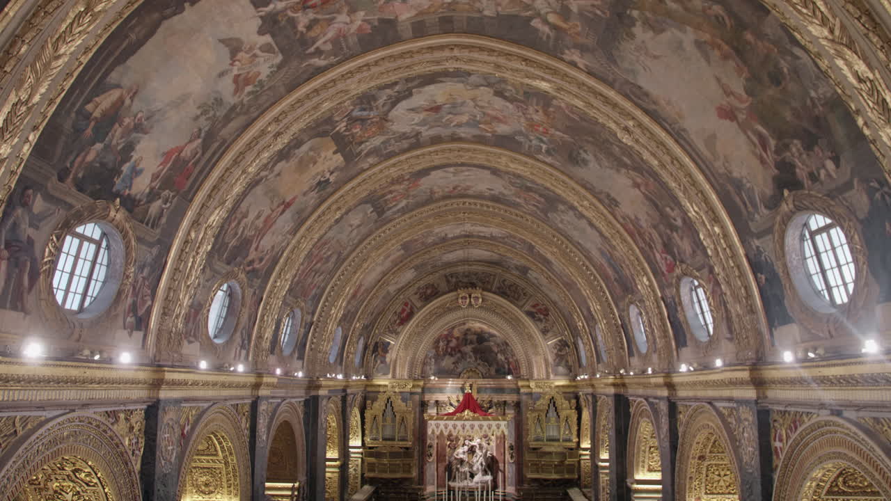 Static shot of painted ceiling and golden interior of Saint John's Co-Cathedral in Valletta, Malta.