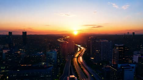 sunset casting a warm glow over a bustling highway, highlighting the vibrant city skyline and evening traffic below