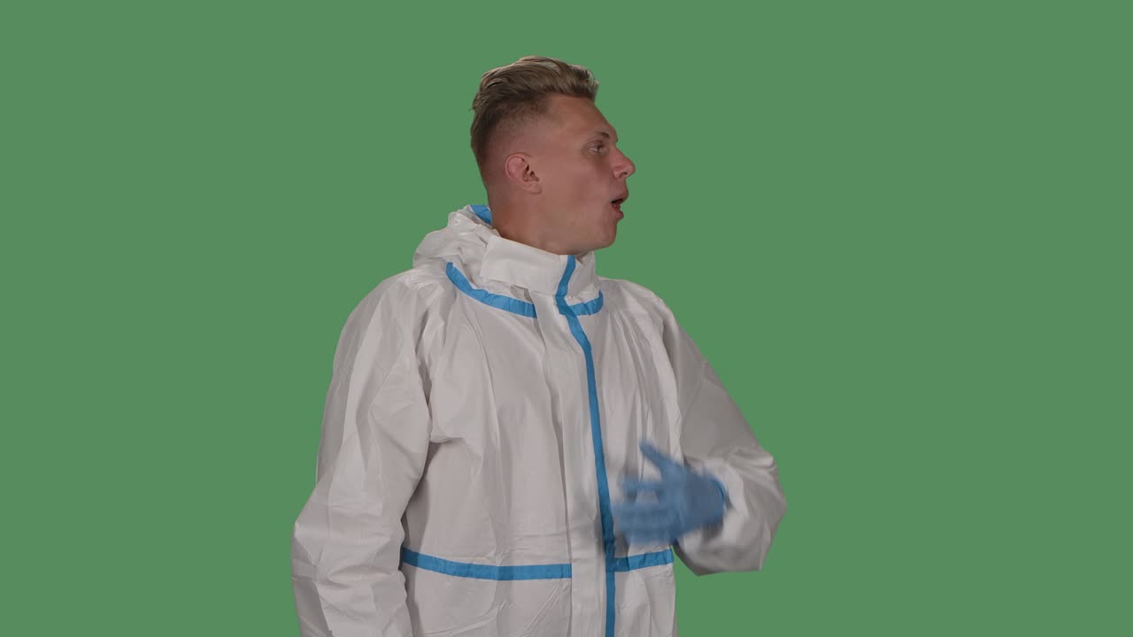 보호복을 입은 남자의 초상화는 카메라를 바라보고 공공장소에서 올바르게 기침하는 방법을 보여줍니다.