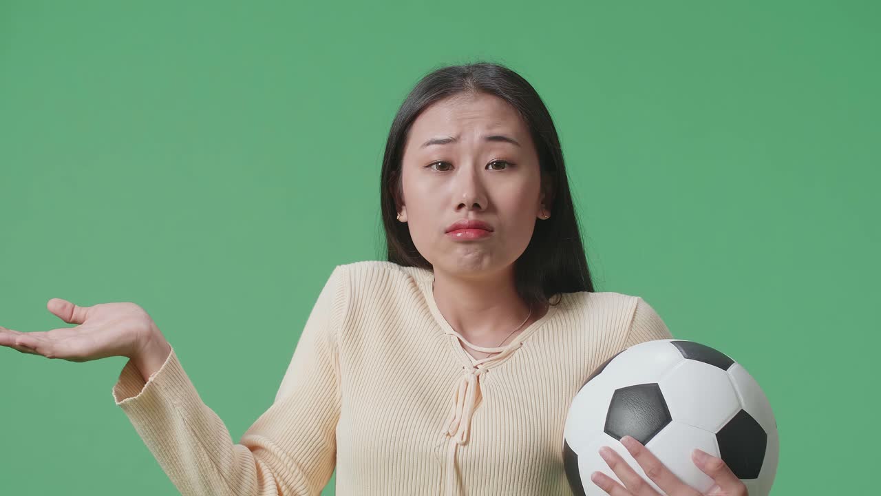 축구공을 들고 있는 여자, 혼란스러워 보인다
