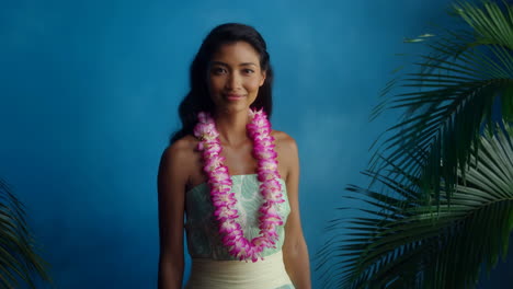 beautiful woman wearing a lei against a blue background