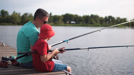 father and son fishing on a pier