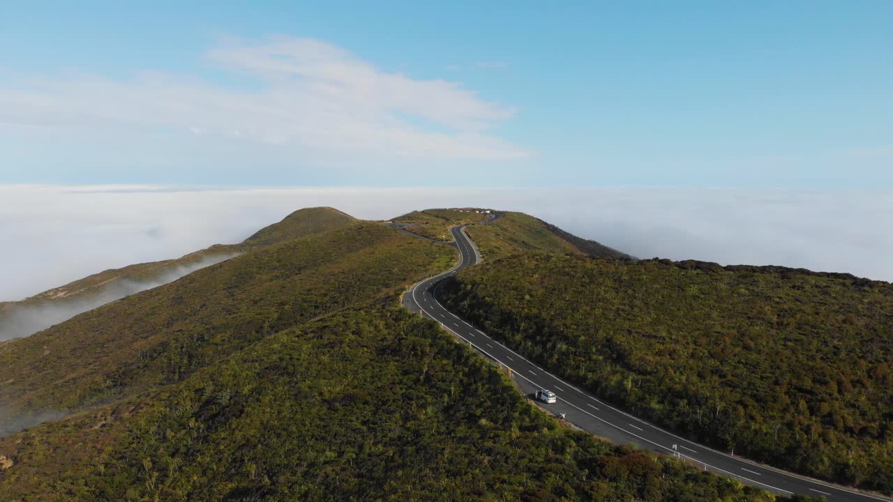 4k의 화창한 여름 아침에 유명한 케이프 레인가 뉴질랜드로 이어지는 언덕 높은 빈 도로의 드론 샷