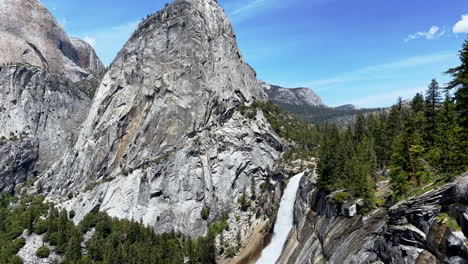 a beautiful scene of a large waterfall on a trail in yosemite national park