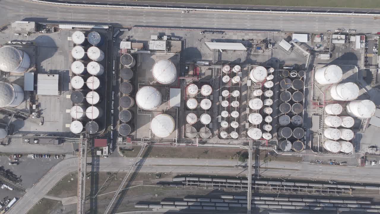 Aerial shot of a petrochemical terminal featuring numerous storage tanks and pipeline systems used for handling industrial liquids.