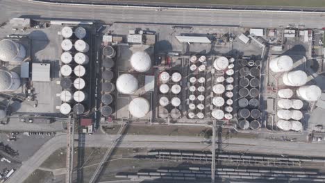 aerial shot of a petrochemical terminal featuring numerous storage tanks and pipeline systems used for handling industrial liquids.