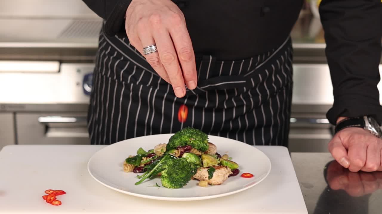 Chef Seasoning a Delicious Chicken and Broccoli Pasta Dish