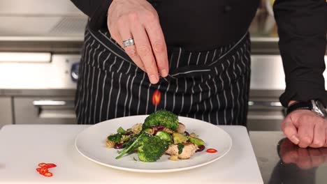 chef seasoning a delicious chicken and broccoli pasta dish
