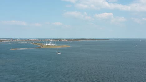 Drone---Aerial-shot-of-sailing-boats-on-a-blue,-wavy-and-windy-sea-on-a-sunny-day-with-white-clouds,-25p