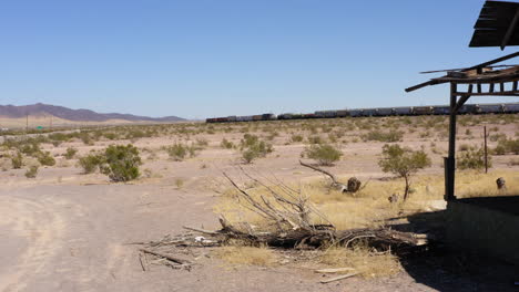 la casa abandonada se sienta sola mientras el tren de carga pasa detrás