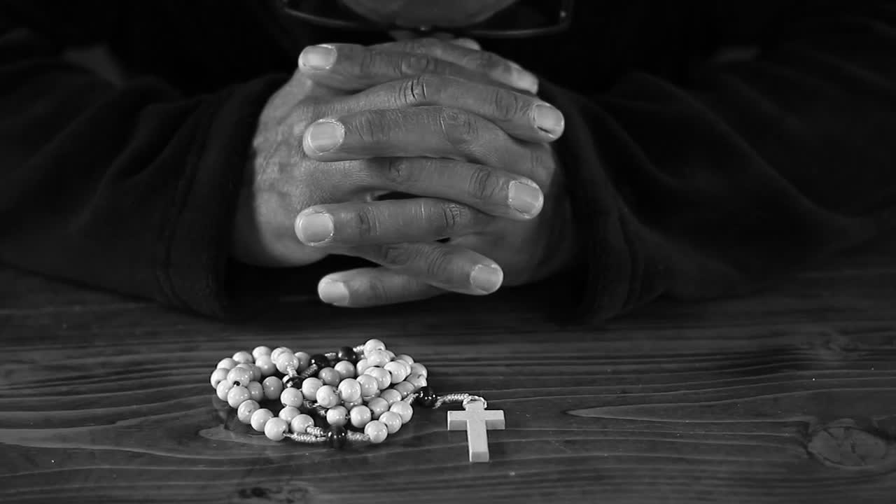 Preghiera a Dio con mani giunte e croce, persone su sfondo nero, video stock.