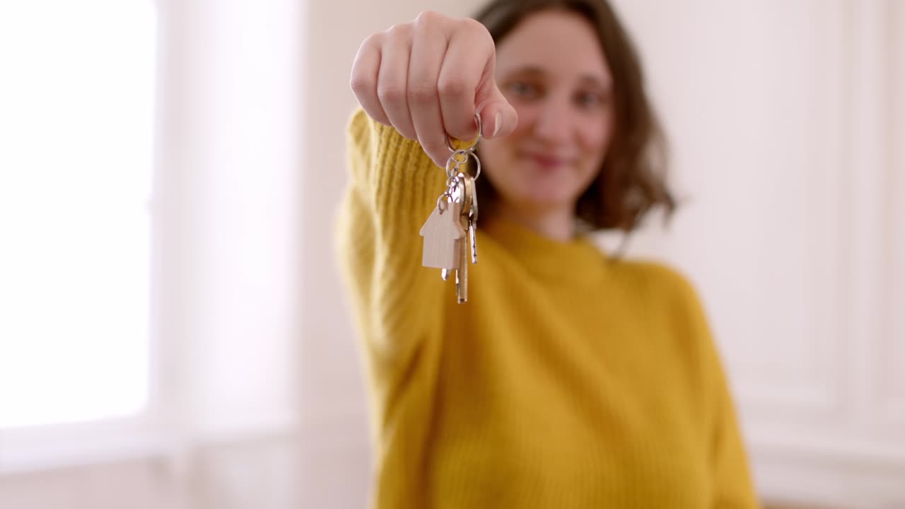 mujer desfocalizada sosteniendo llaves. disparo de enfoque selectivo