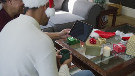 Padre-E-Hijo-Sonrientes-Haciendo-Videollamadas-Navideñas-En-Una-Tableta-Digital-Con-Espacio-Para-Copiar-En-Casa