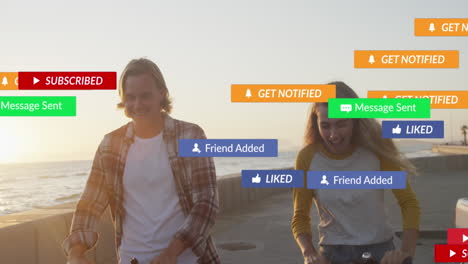 animation of social media text and icons over caucasian couple on beach