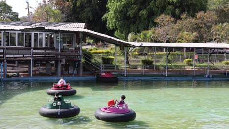 people enjoying bumper boats in a water attraction