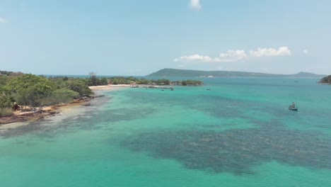 Shallow-coast-of-M'pai-Bay,-with-clean-turquoise-warm-water-surrounding-Koh-Rong-Sanloem-island,-Cambodia---Aerial-Slide-wide-shot