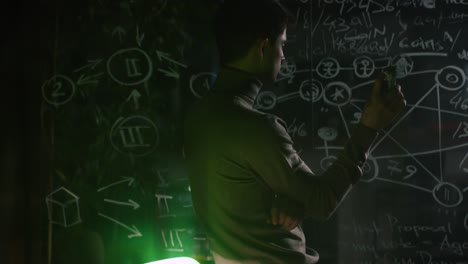 hombre estudiando un diagrama complejo en una pizarra