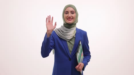 smiling muslim businesswoman in hijab waving and holding a folder