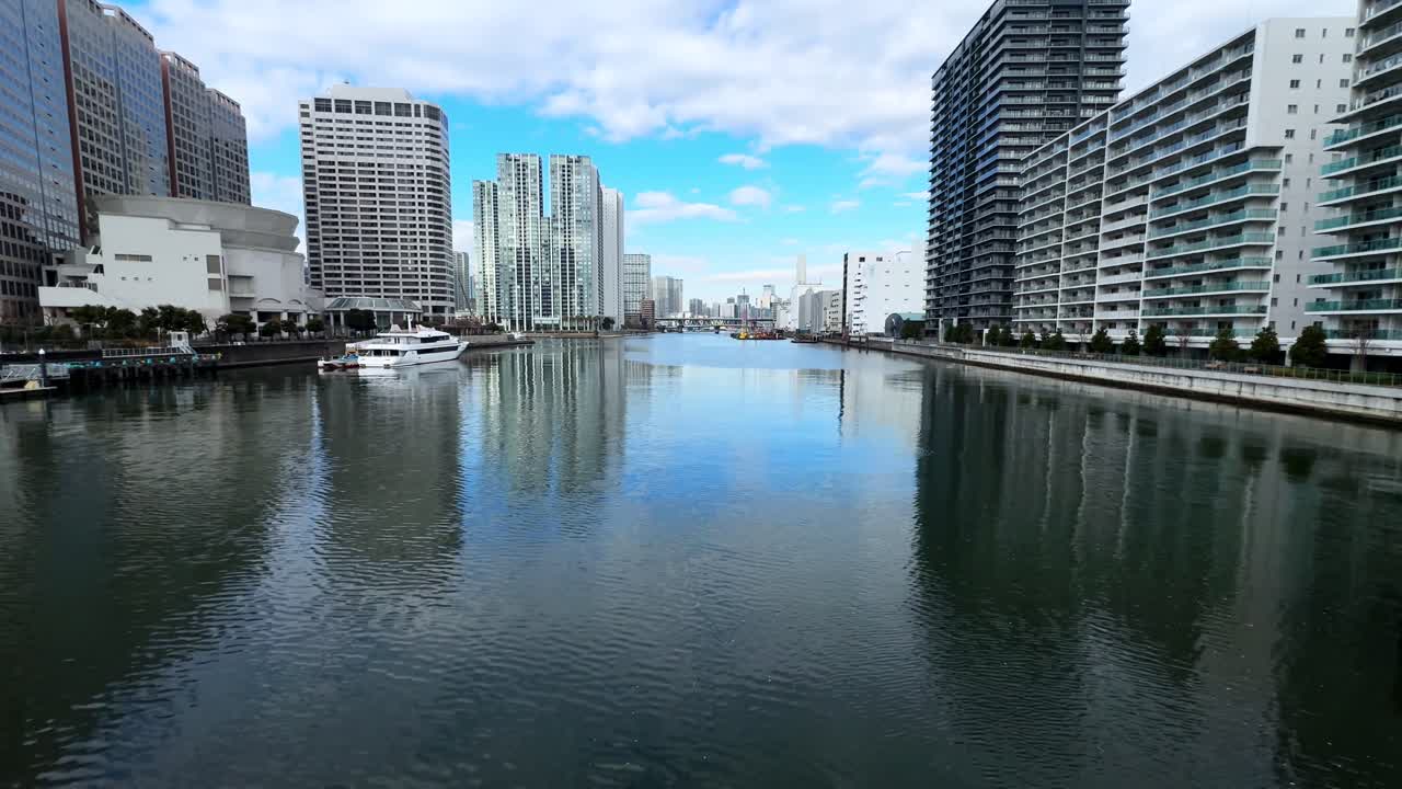 A peaceful canal in Tokyo surrounded by modern buildings on a sunny day