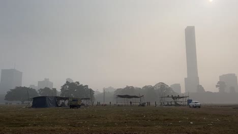 brigade maidan ground on a foggy winter morning with some stalls and vehicles present on it in kolkata, india