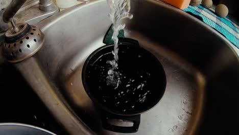 slow motion - flowing water from a sink faucet in the kitchen