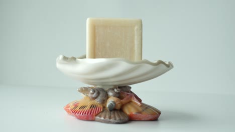plato decorativo de jabón de conchas marinas con una barra de jabón