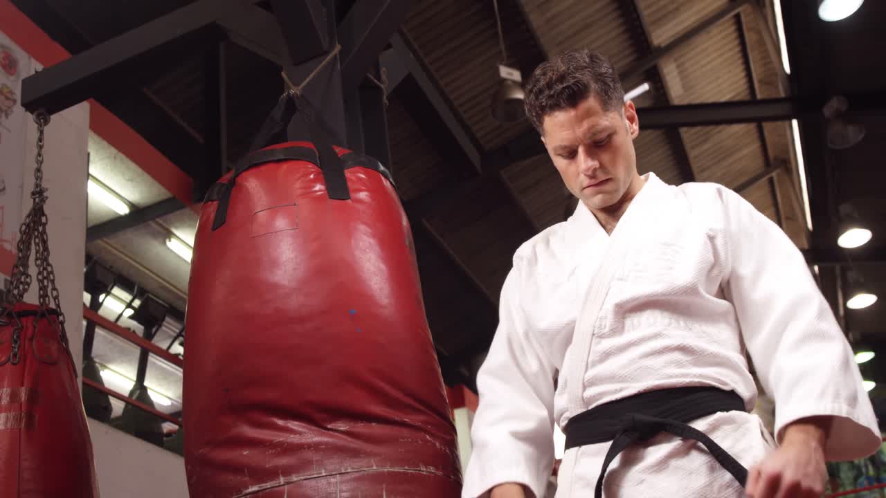 검은 벨트 를 입은 남자 가 피트니스 스튜디오 에 서 있다